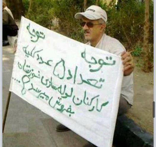 Iranian man holding a sign