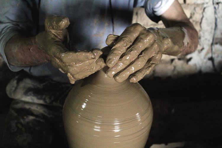 Old hands making pottery